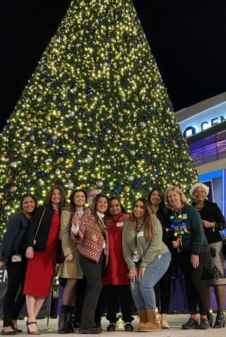 UCSF OHNS team members at the department holiday party standing in front of a large Christmas tree.