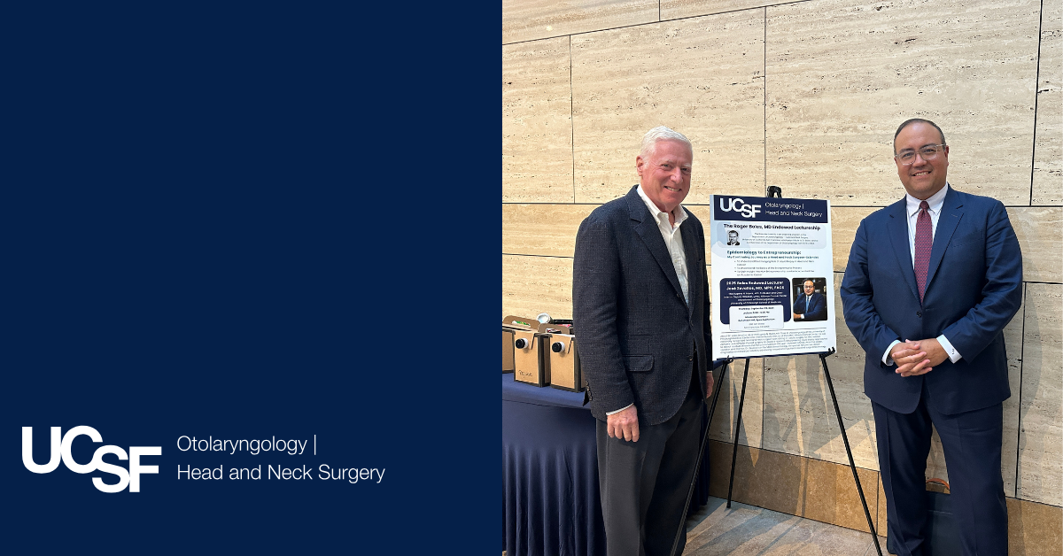 Dr. Murr stands next to an event sign for the Boles Lectureship with the guest lecturer, Dr. Zevallos.