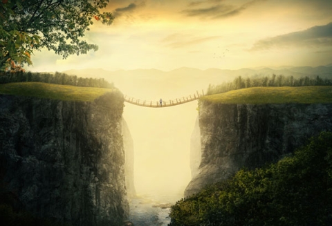 a-man-stands-alone-on-a-bridge-between-two-mountains