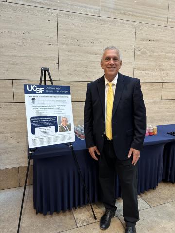 Dr. Sam Selesnick in front of lecture poster 